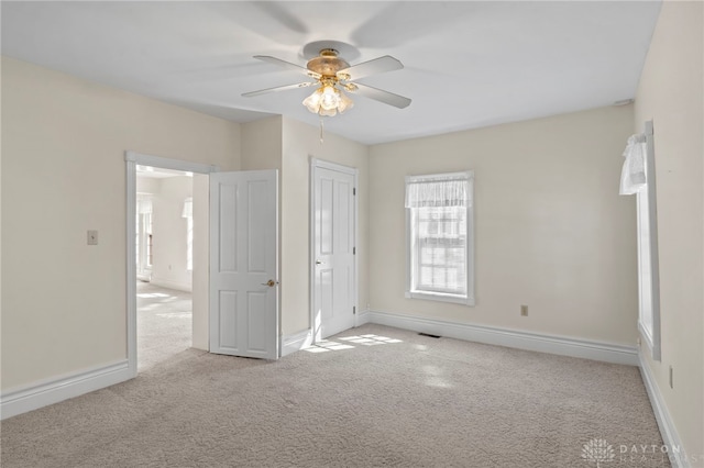 unfurnished bedroom with light colored carpet and ceiling fan