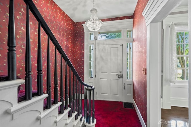 foyer featuring dark hardwood / wood-style flooring and an inviting chandelier