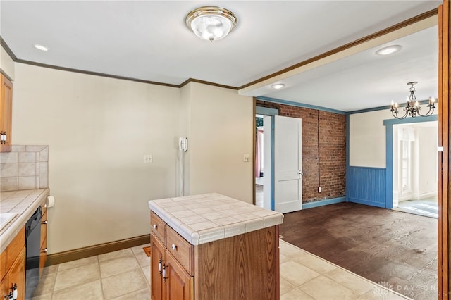 kitchen featuring tile counters, a kitchen island, light hardwood / wood-style floors, and black dishwasher