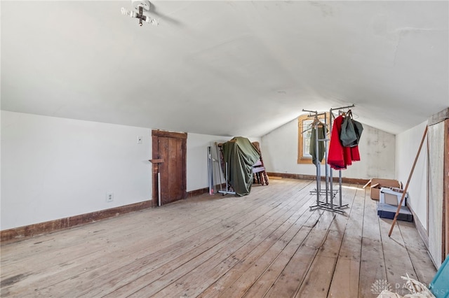 bonus room with vaulted ceiling and light hardwood / wood-style flooring