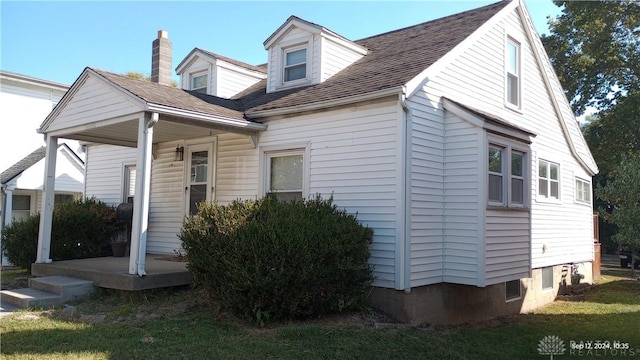 view of front of house featuring roof with shingles and a front lawn