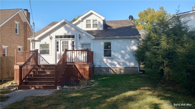 rear view of house with a yard, stairway, a wooden deck, and a shingled roof