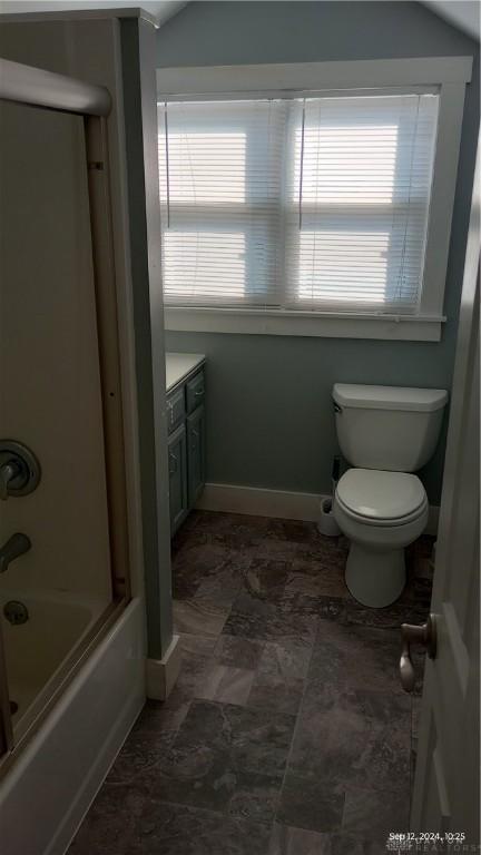 bathroom featuring vanity, bathing tub / shower combination, toilet, and baseboards