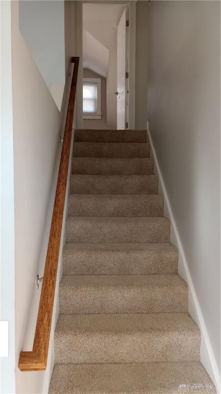 stairs featuring vaulted ceiling