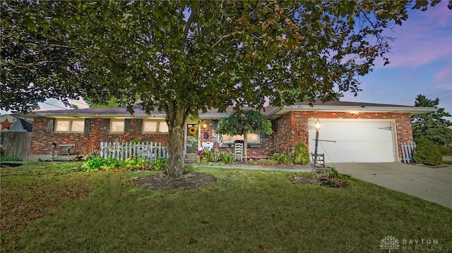 single story home featuring a lawn and a garage