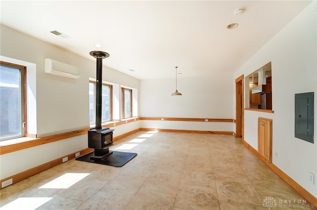 unfurnished living room featuring a wood stove, electric panel, and an AC wall unit