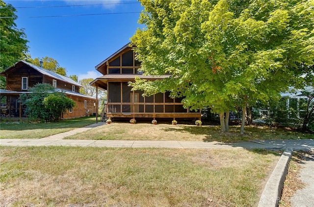 view of front of house featuring a sunroom and a front lawn