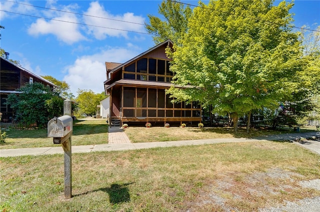 view of front facade featuring a front yard and a sunroom