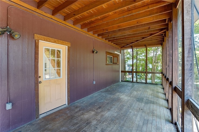 unfurnished sunroom featuring wooden ceiling and beamed ceiling