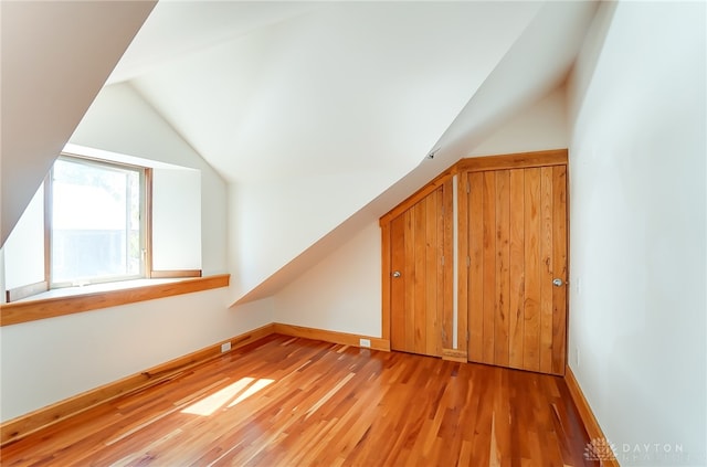 bonus room with vaulted ceiling and light hardwood / wood-style flooring