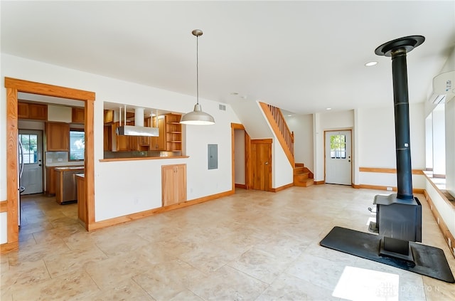 interior space featuring decorative light fixtures, electric panel, and a wood stove