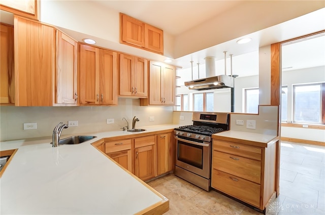 kitchen featuring range hood, stainless steel range with gas stovetop, kitchen peninsula, and sink