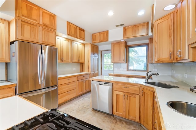 kitchen with appliances with stainless steel finishes, light tile patterned floors, and sink