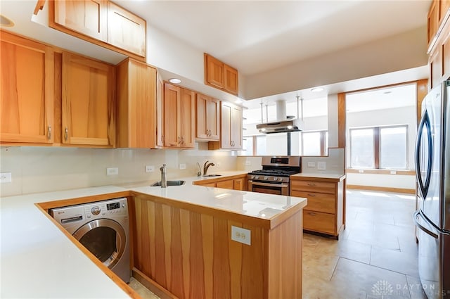 kitchen with washer / dryer, stainless steel appliances, kitchen peninsula, and sink