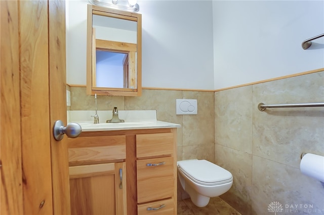 bathroom with vanity, toilet, and tile walls