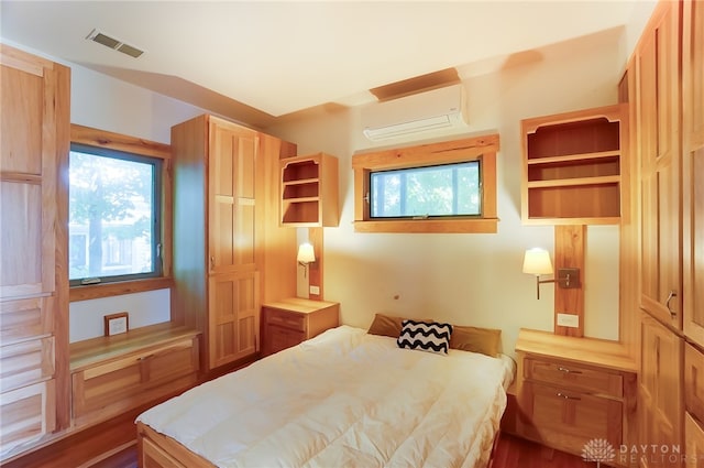 bedroom featuring dark hardwood / wood-style floors and a wall mounted air conditioner