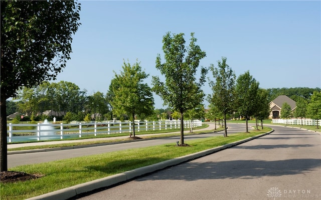 view of property's community featuring a lawn and a water view