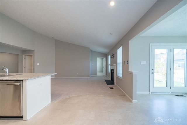 kitchen with dishwasher, light carpet, vaulted ceiling, and sink