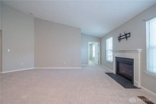 unfurnished living room with lofted ceiling and light carpet