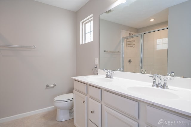 bathroom featuring vanity, toilet, and a shower with door