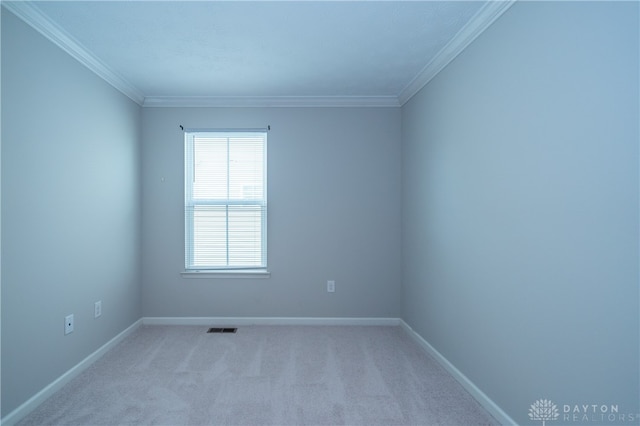 empty room featuring crown molding and light colored carpet