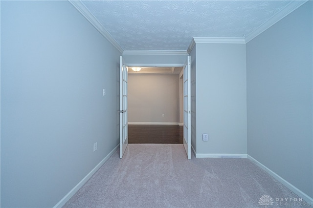 carpeted empty room with ornamental molding and a textured ceiling