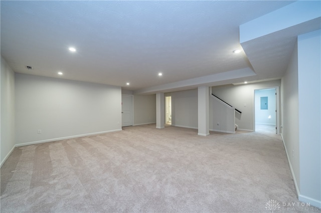 basement featuring light carpet and electric panel