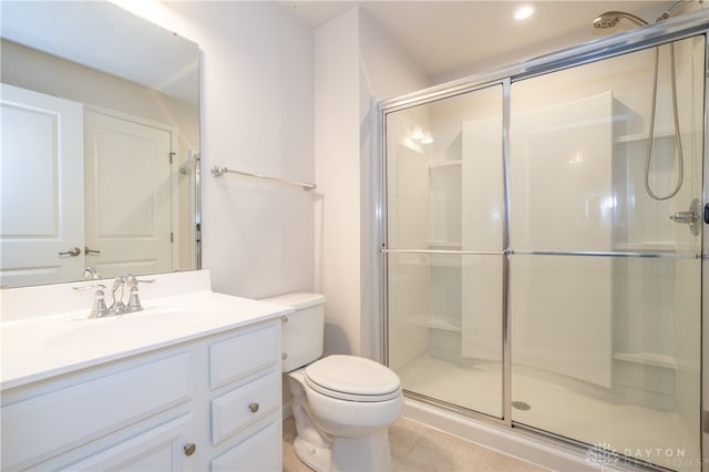 bathroom with tile patterned floors, toilet, vanity, and walk in shower