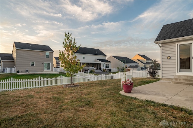 yard at dusk featuring a patio area