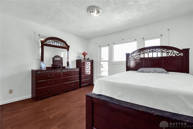 bedroom with dark wood-type flooring and a textured ceiling