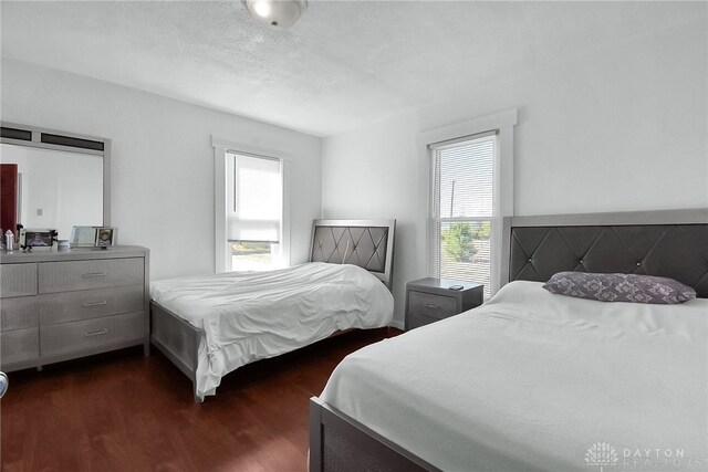 bedroom with dark wood-type flooring, multiple windows, and a textured ceiling