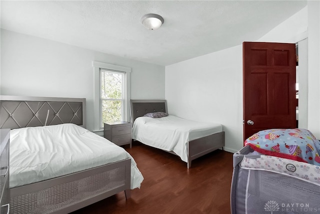 bedroom with dark wood-type flooring and a textured ceiling