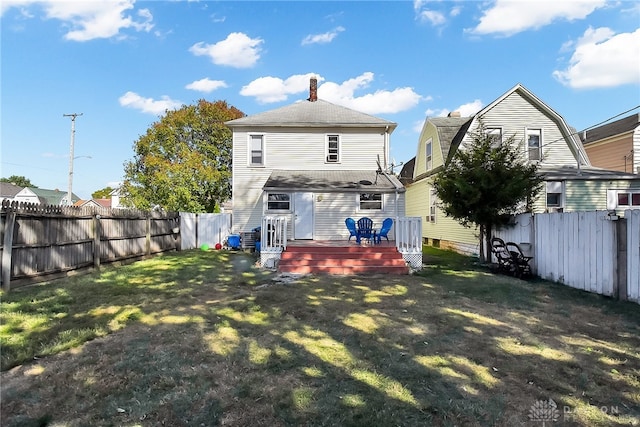 back of property with a yard and a deck