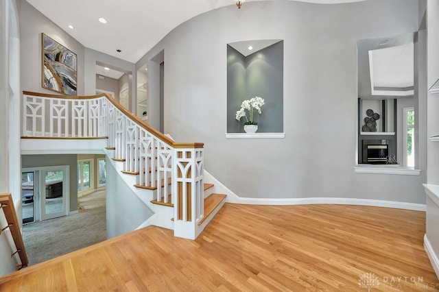 stairs with french doors and hardwood / wood-style floors