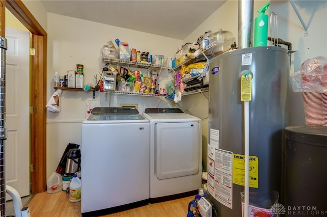 laundry area featuring washer and dryer, gas water heater, and light wood-type flooring