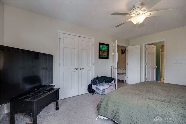 bedroom featuring carpet, a closet, ensuite bath, and ceiling fan