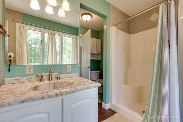 bathroom with a shower with curtain, hardwood / wood-style floors, vanity, and toilet