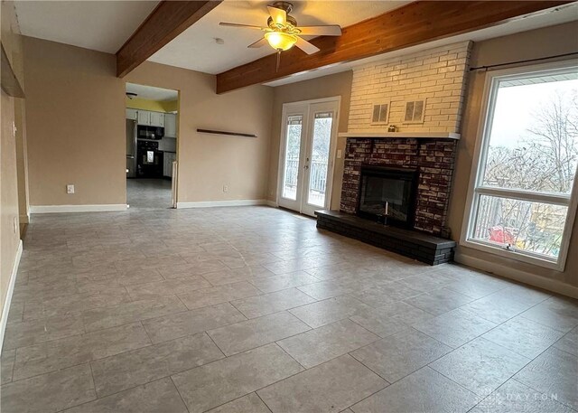 unfurnished living room with ceiling fan, beamed ceiling, and a brick fireplace