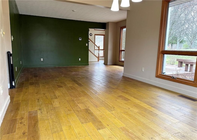 spare room with a healthy amount of sunlight and light hardwood / wood-style floors