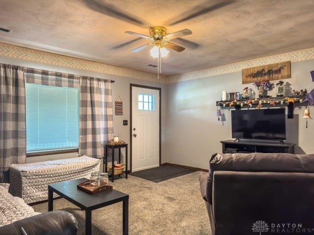 carpeted living room featuring ceiling fan