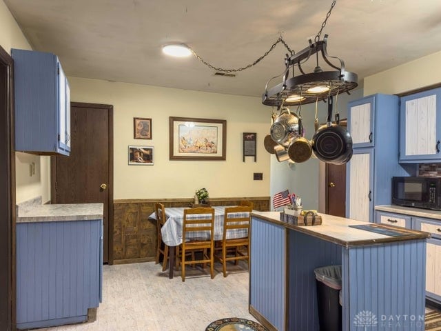 kitchen with wooden walls, a kitchen bar, and blue cabinetry