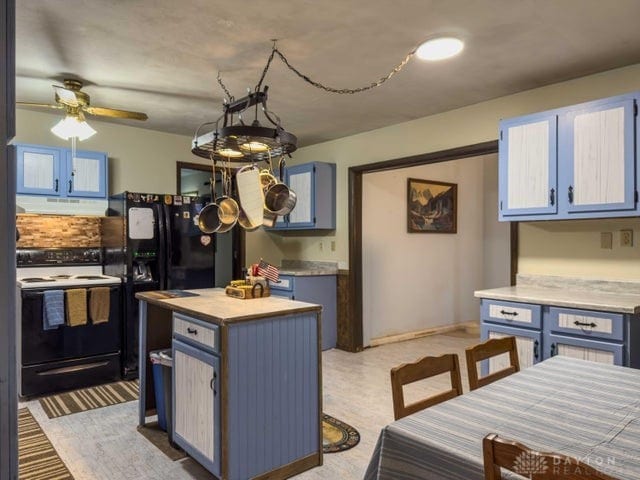 kitchen featuring hanging light fixtures, blue cabinets, a kitchen island, white electric stove, and ceiling fan