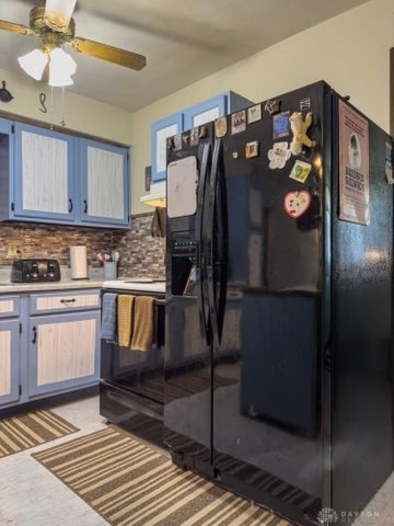 kitchen with backsplash, ceiling fan, and black fridge