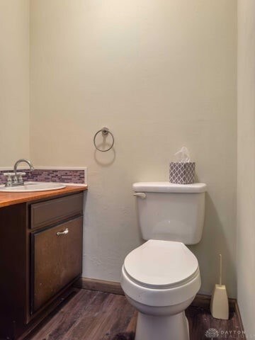 bathroom with wood-type flooring, vanity, and toilet