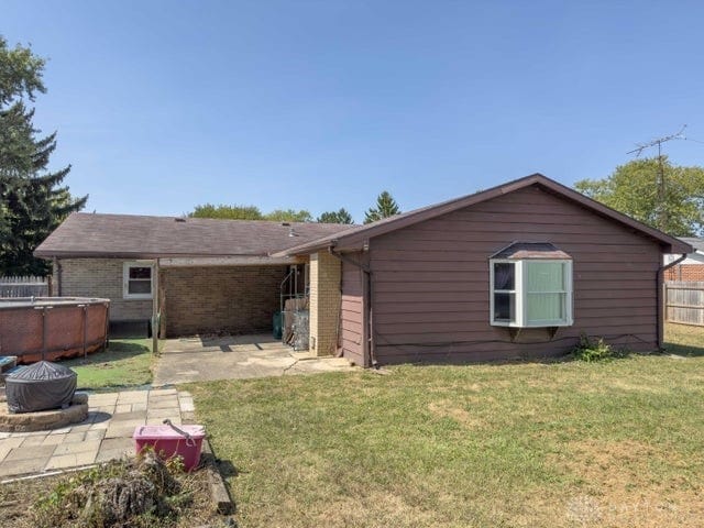 rear view of property featuring a patio and a yard