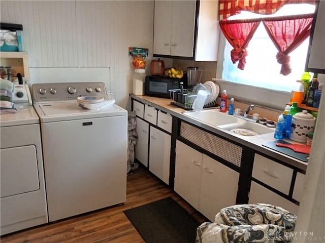 washroom featuring dark hardwood / wood-style flooring, washer and clothes dryer, and sink