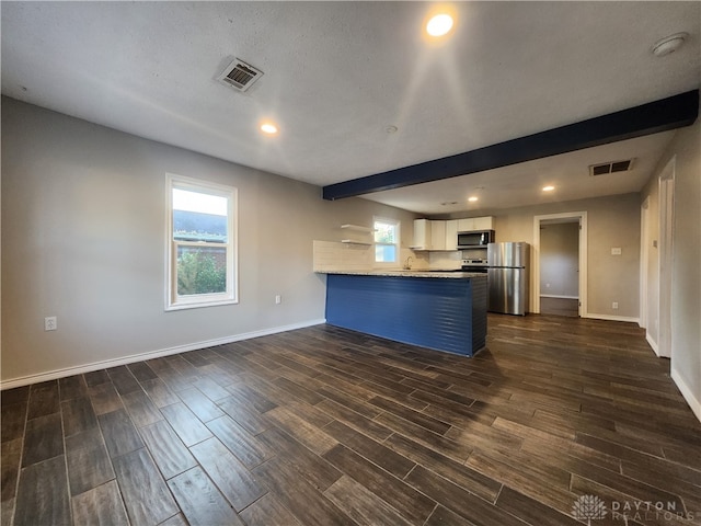 kitchen featuring kitchen peninsula, white cabinetry, plenty of natural light, and appliances with stainless steel finishes