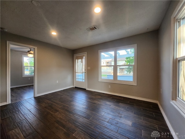 unfurnished room with a textured ceiling, dark hardwood / wood-style floors, and ceiling fan