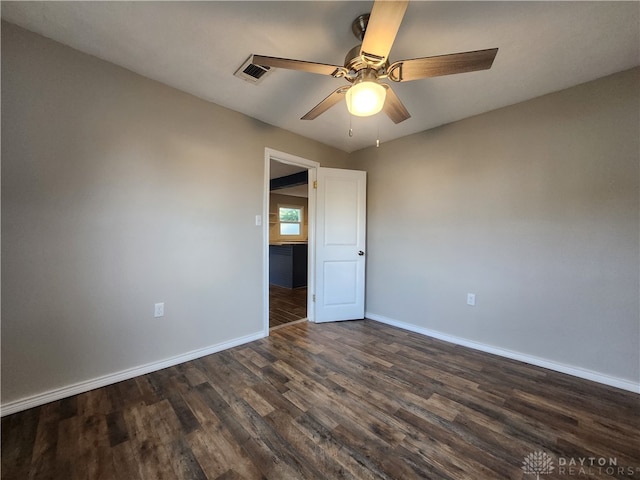 spare room featuring ceiling fan and dark wood-type flooring