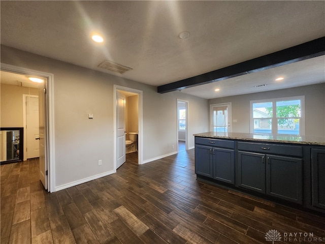 interior space with beamed ceiling, dark hardwood / wood-style floors, and light stone counters